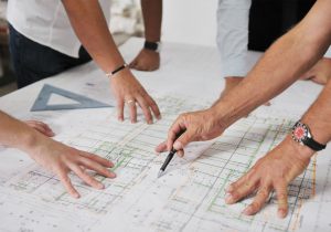 Hot Property Group image of four men studying house renovations plans.